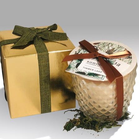 Holiday candle in glass jar with golden box and green ribbon
